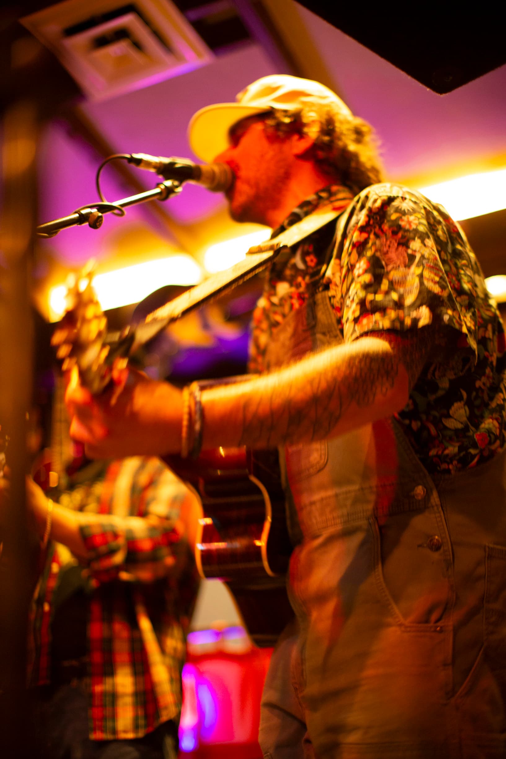 Side profile of Ty Stonehawker playing guitar and singing